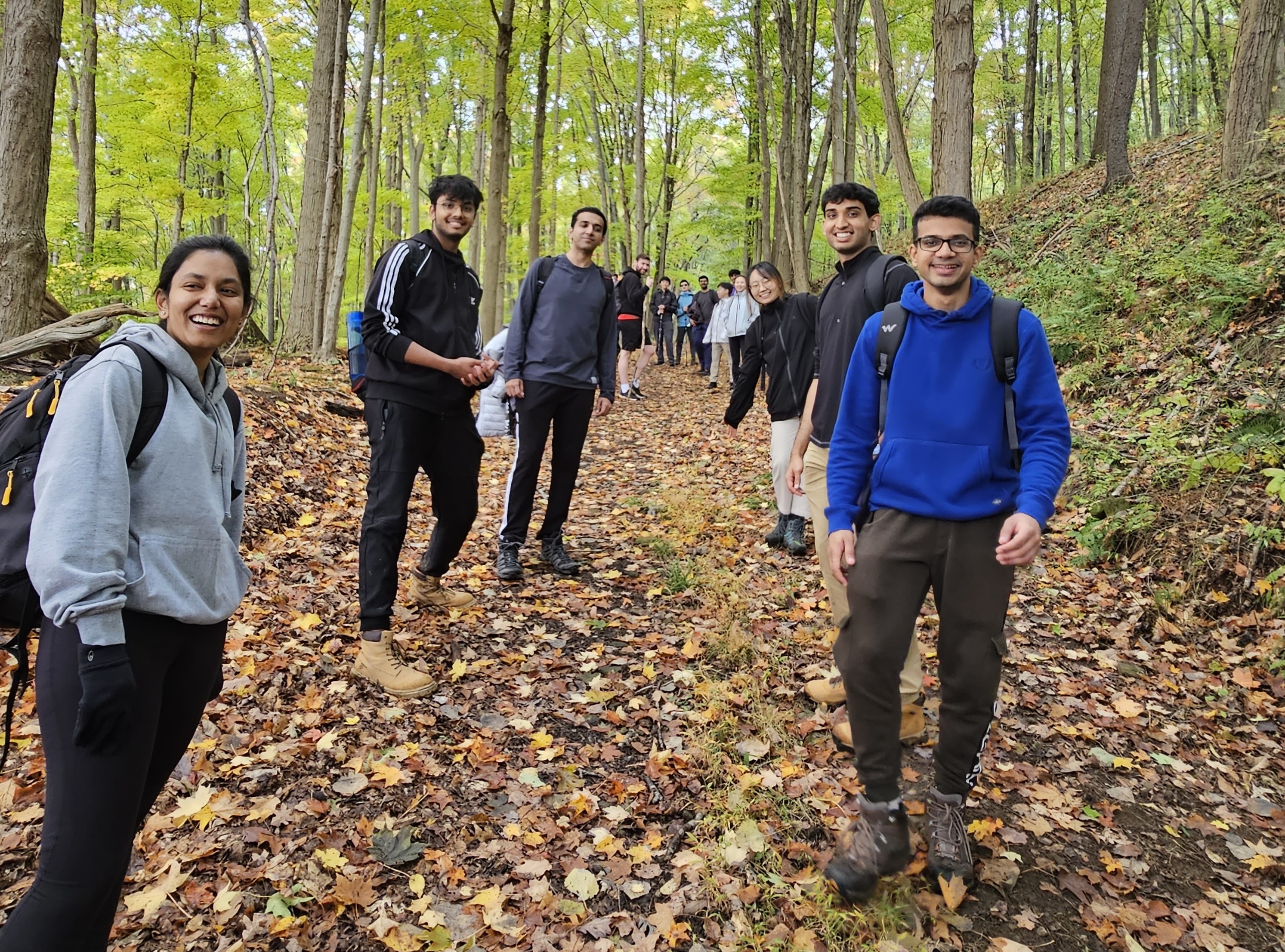 Photo of a group of LTI students smiling while hiking through the woods