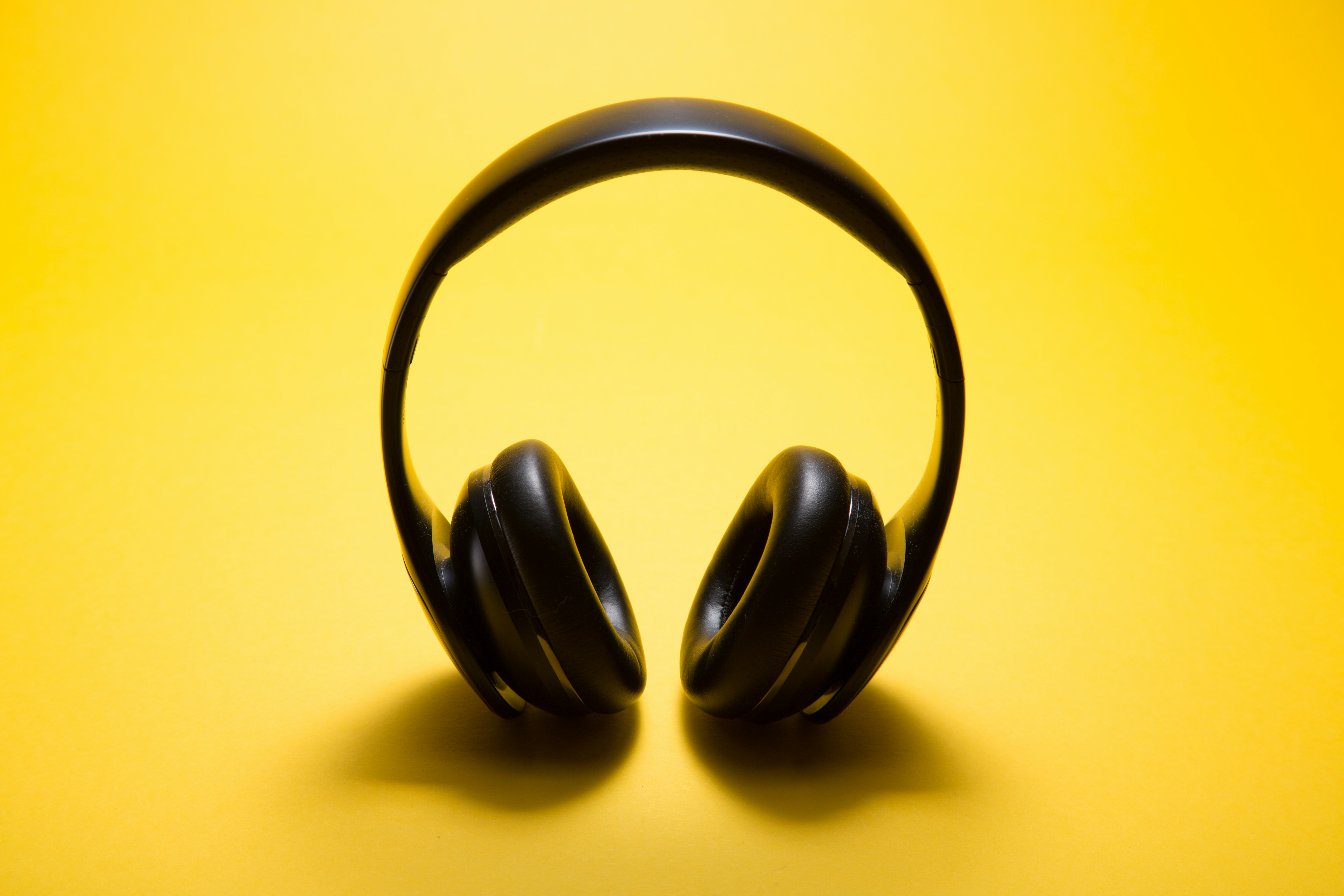 Black headphones over a yellow background