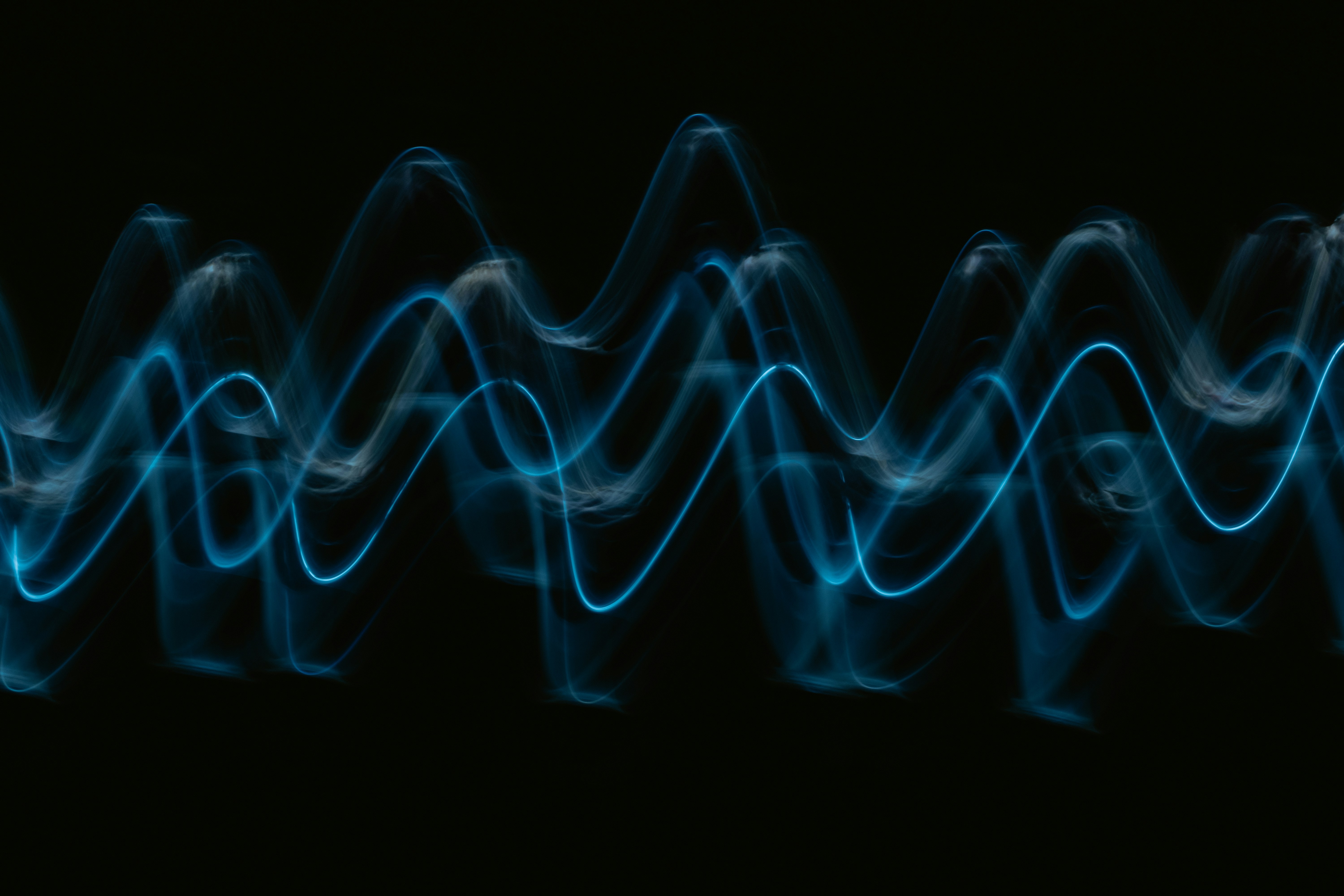 An abstract representation of soundwaves, green on a black background
